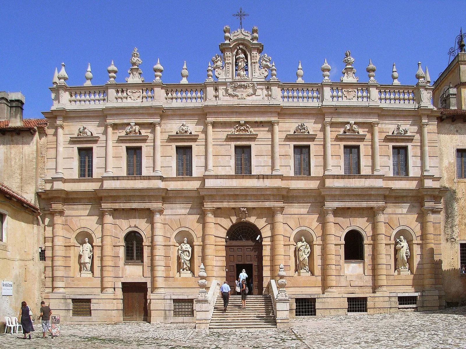 La facciata barocca della Certosa di Padula sulla corte esterna lastricata, con statue nelle nicchie e la scalinata d'ingresso